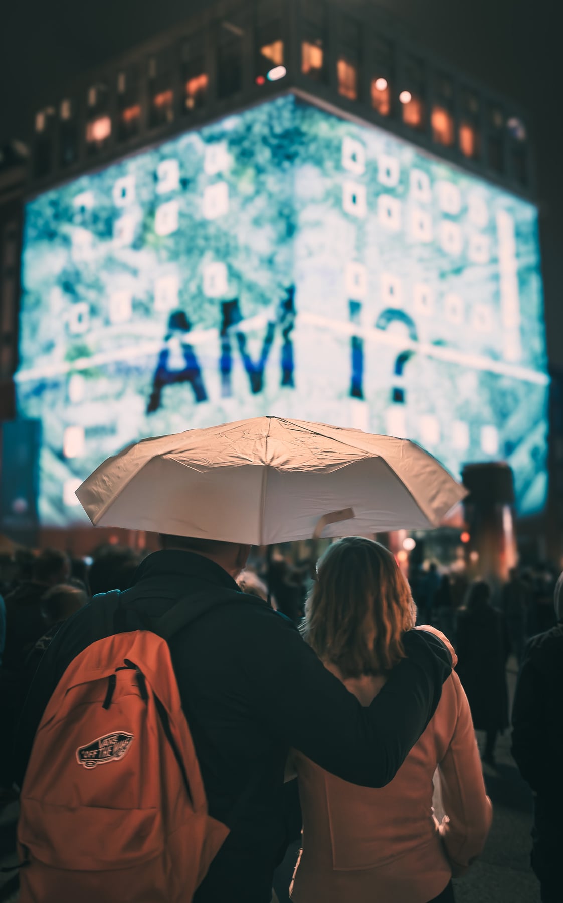 Besucher unter einem Regenschirm vor dem beleuchteten Dortmunder U.