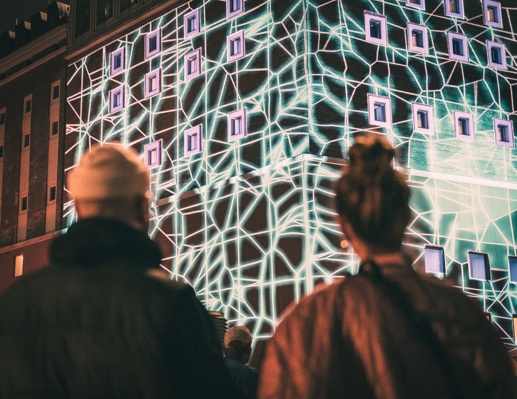 Geometrische Lichtprojektionen am Dortmunder U mit Publikum im Vordergrund.